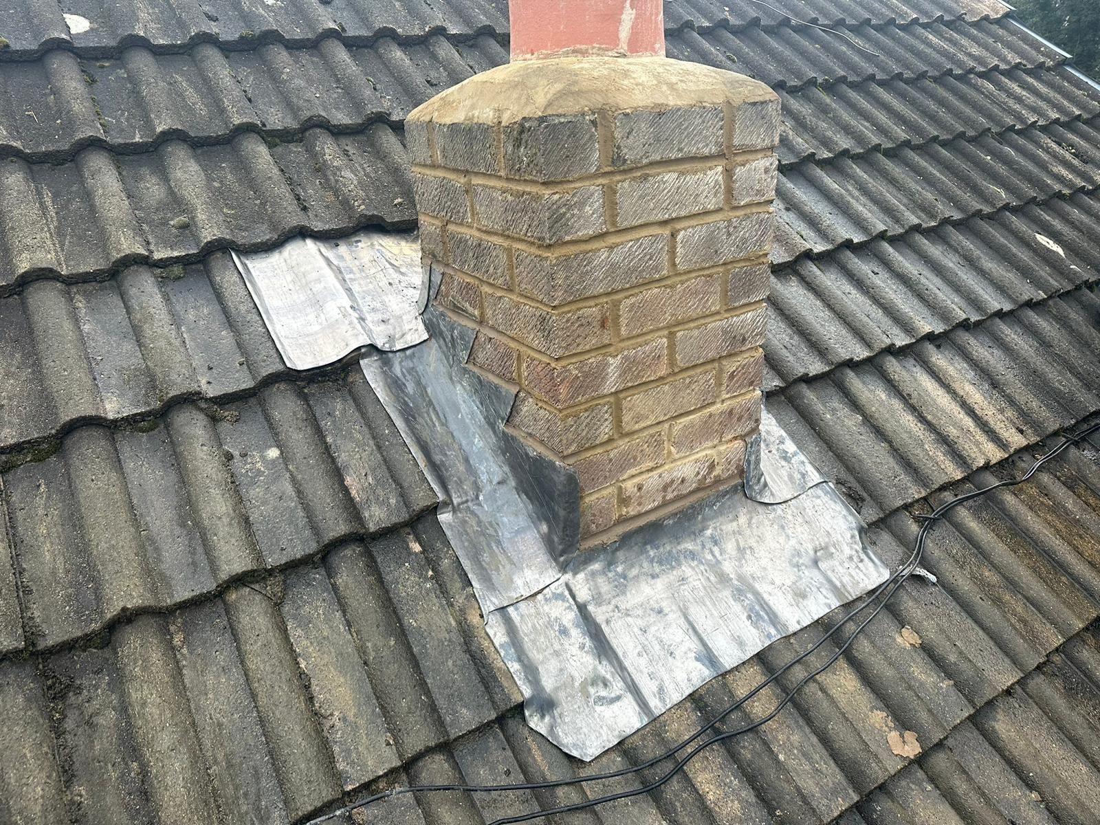 Chimney with new lead flashing on a concrete tiled roof