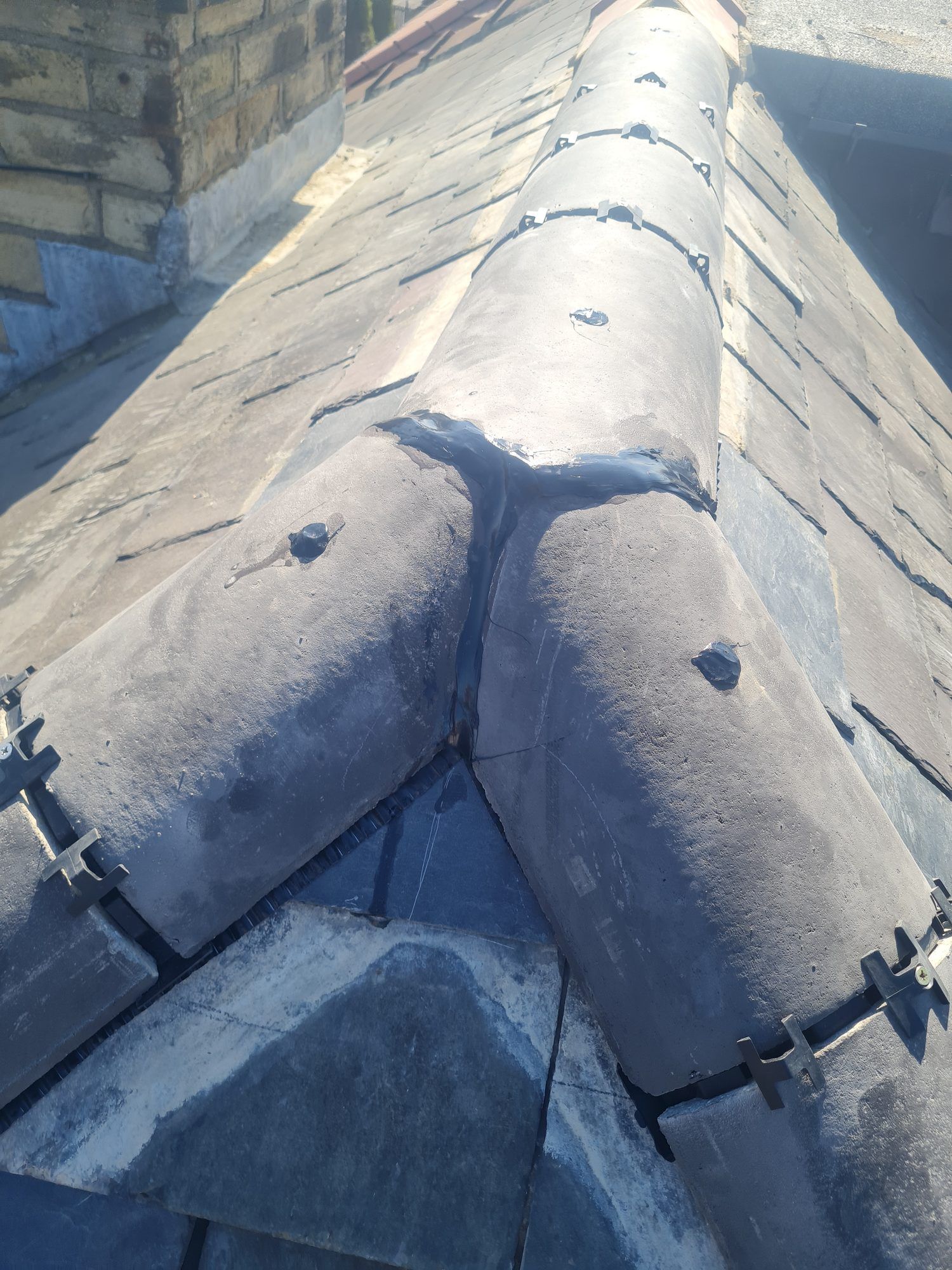 Close-up of a dry-fix hip and ridge junction on a slate roof