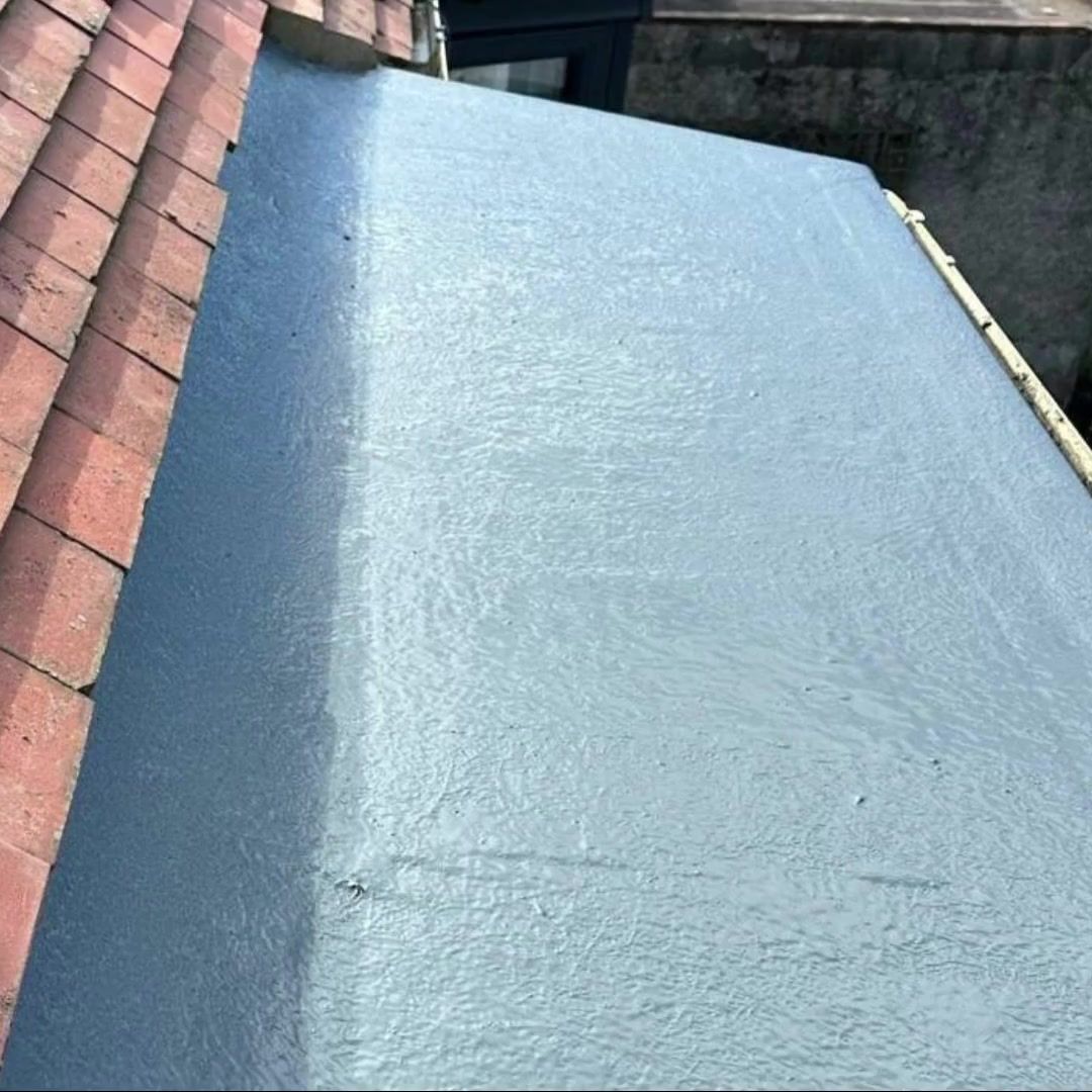 Finished grey GRP fibreglass flat roof beside red roof tiles