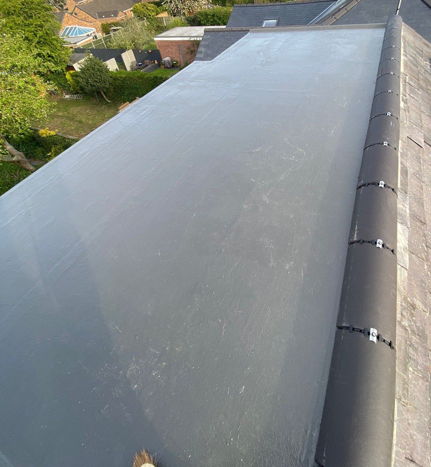 New grey GRP fibreglass flat roof with neat trims, overlooking gardens