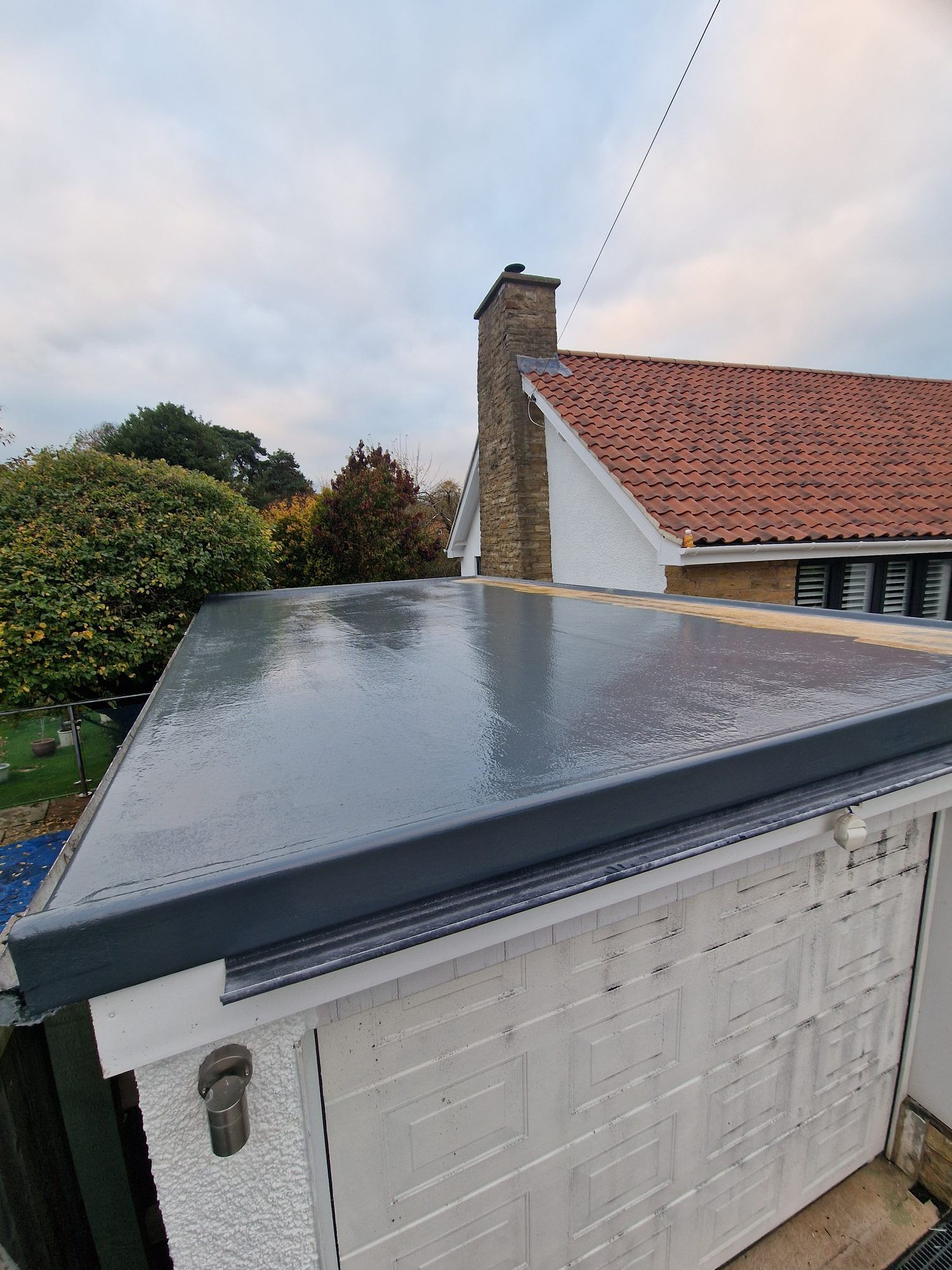 New GRP flat roof on a garage, with a tiled house roof behind