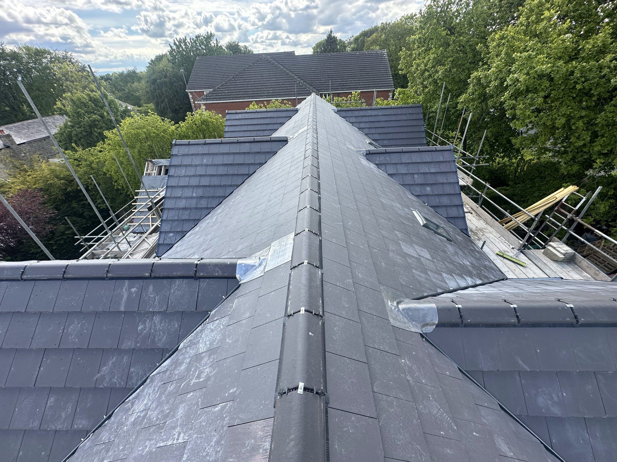 New slate hip roof with dry hips, among trees