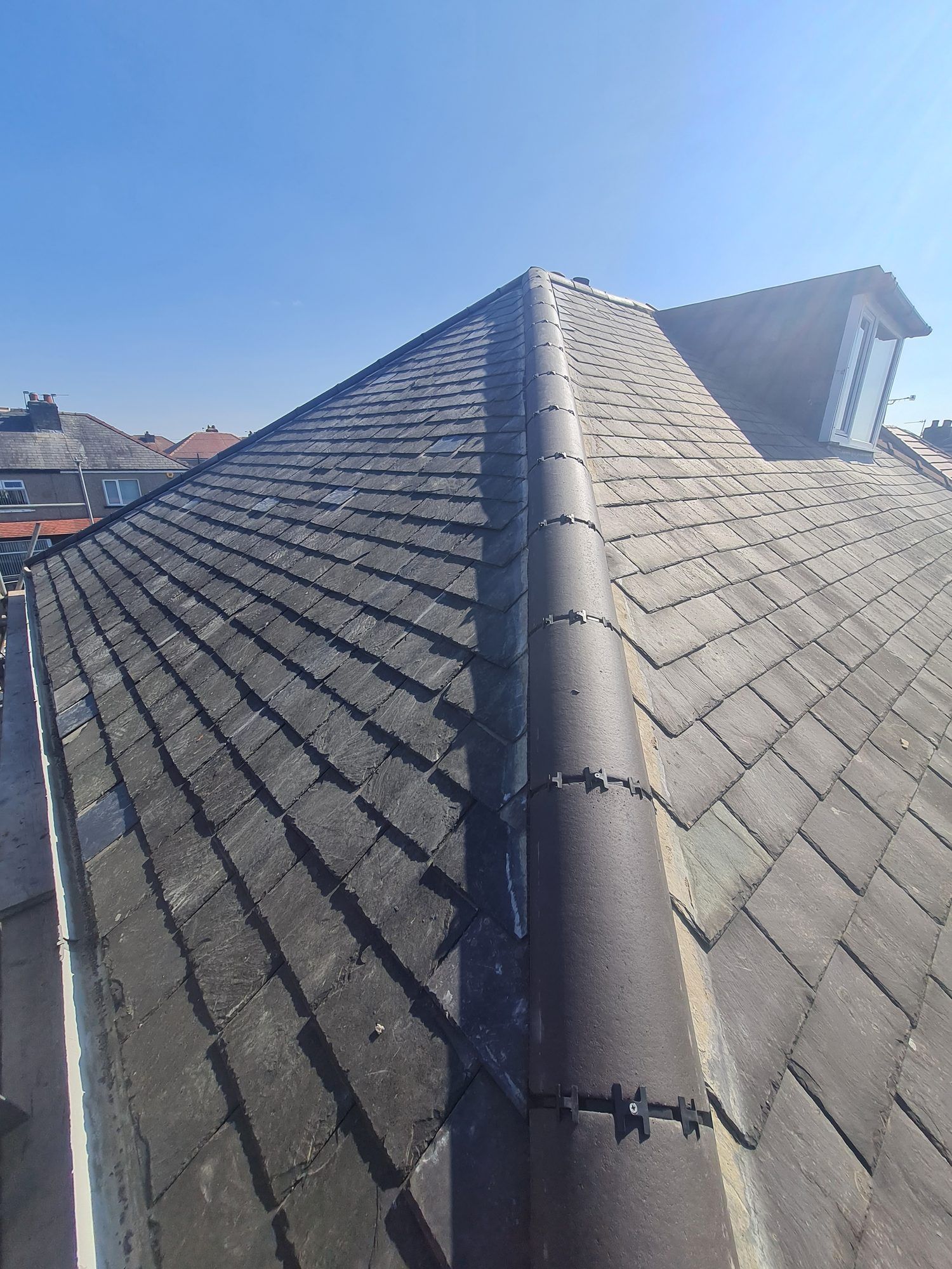 Slate roof with a new dry ridge in low sun