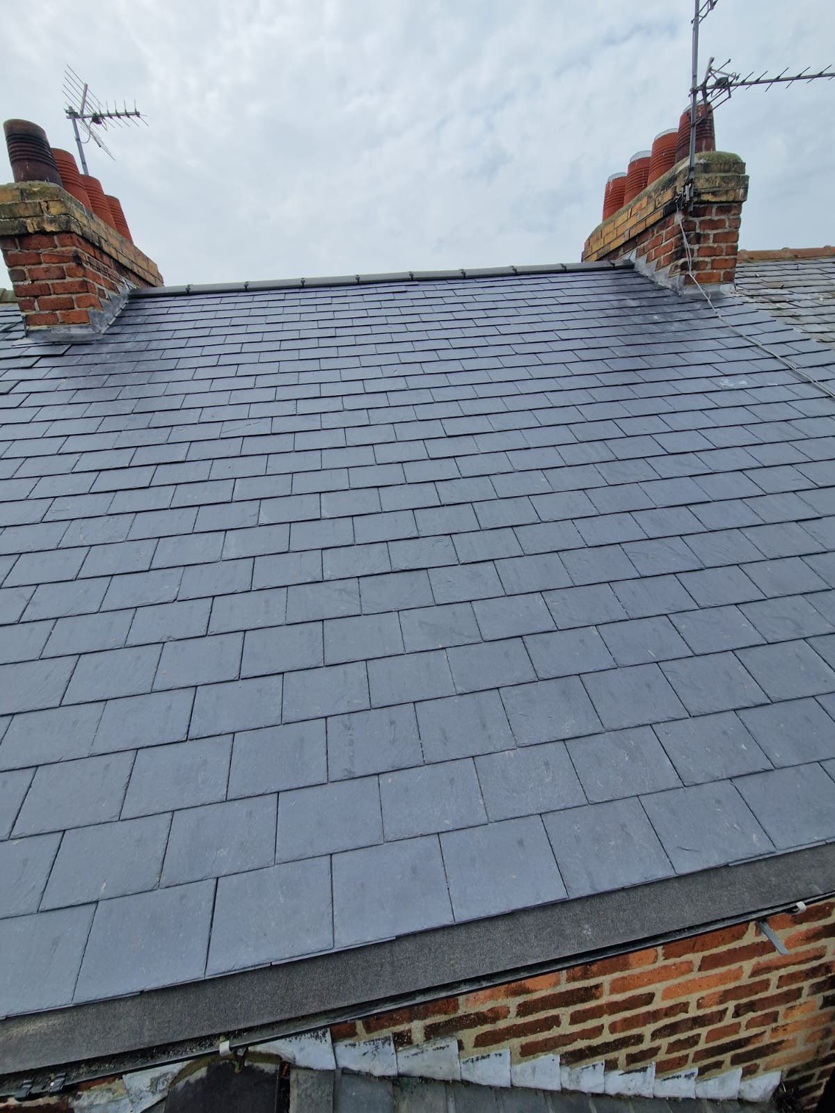 Slate roof between two brick chimney stacks