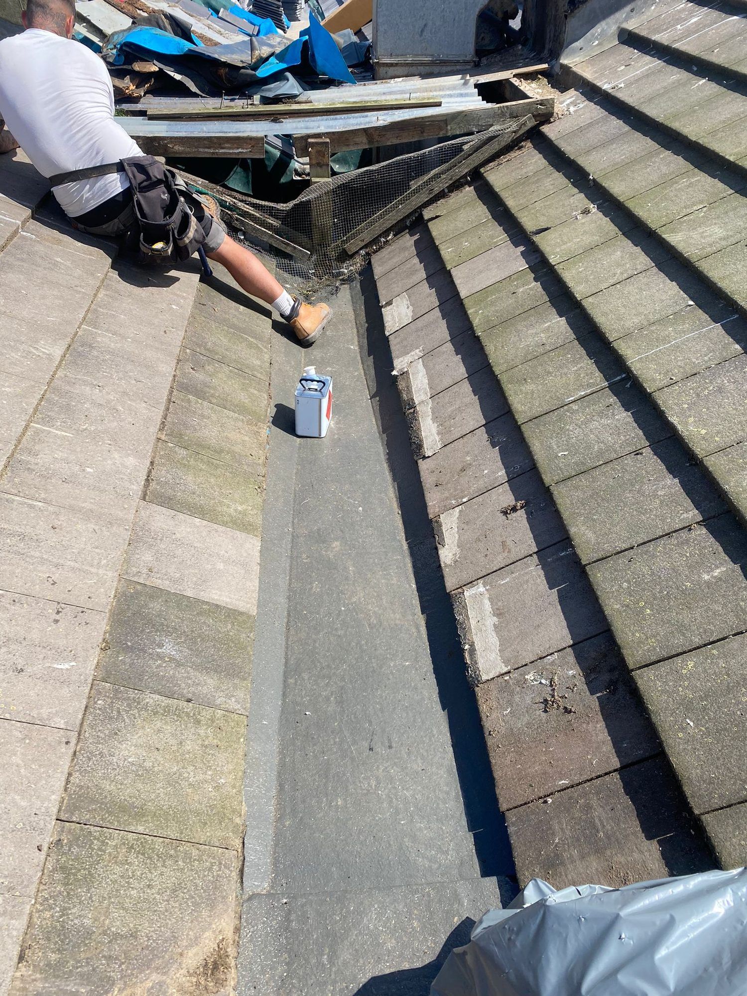Roofer working in the valley between two tiled roof slopes